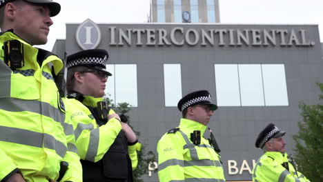 A-cordon-of-police-officers-at-the-entrance-to-an-Intercontinental-Hotel-opens-up-and-one-officer-waves-someone-through-during-a-public-order-incident