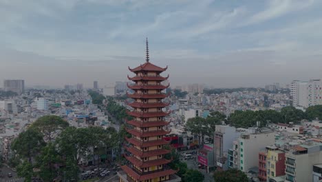 Video-of-Buddhist-Pagoda-in-Ho-Chi-Minh-City,-Vietnam-with-prayer-tower-and-red-roof-situated-in-densely-populated-area-of-the-city