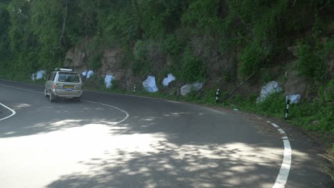 Kurvenreiche-Bergstraße-Mit-Warnschildern,-Die-Auf-Eine-Kurve-Hinweisen,-Gelbes-Schild-Mit-Haarnadelkurve