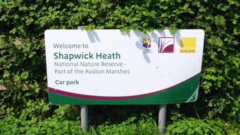 Welcome-to-Shapwick-Heath-national-nature-reserve-part-of-Avalon-Marshes-sign-on-the-Somerset-Levels-in-England-UK
