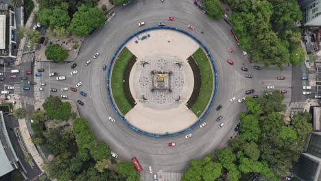 Drone-footage-in-slow-motion,-highlighting-the-Angel-of-Independence-roundabout-on-Paseo-de-la-Reforma
