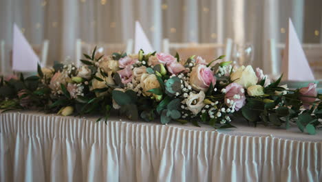 Highlight-the-exquisite-floral-decorations-adorning-a-wedding-venue,-adding-elegance-and-charm-to-the-celebration
