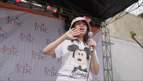 Young-girl-sings-at-an-outdoor-event-in-Jakarta-Barat
