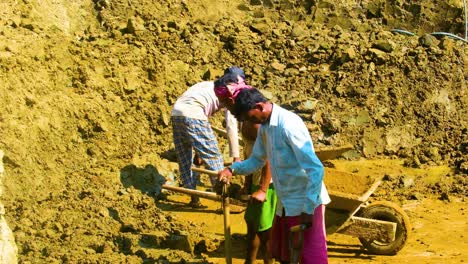 Männliche-Arbeiter-Schaufeln-Schlamm-Und-Lehm-Auf-Dem-Feld-In-Sylhet,-Bangladesch---Weitwinkelaufnahme