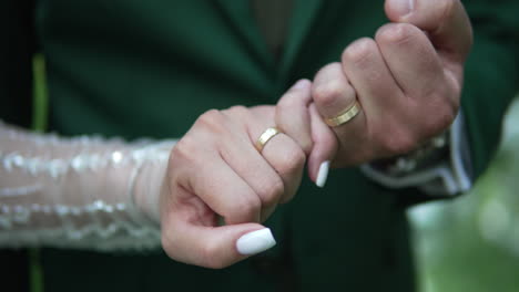 Celebrate-a-romantic-wedding-day-moment-as-the-bride-and-groom-hold-hands,-showcasing-their-wedding-rings-and-the-deep-bond-of-love-and-commitment