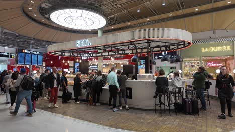 Dining-travelers-around-the-Strada-Italian-authentic-restaurant-at-the-Charles-de-Gaulle-airport-in-Paris,-France