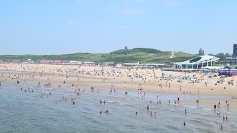 Summer-time-on-Scheveningen-beach-with-locals-and-tourists-swimming-in-the-water-of-the-North-Sea