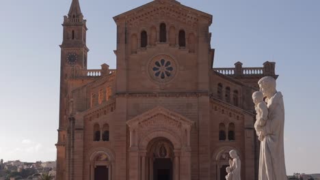 The-sunlit-view-of-the-Basilica-of-the-Blessed-Virgin-of-Ta'-Pinu-on-Gozo-Island,-Malta,-highlights-the-spiritual-heritage-and-scenic-beauty