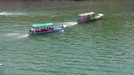 Ferry-Turístico-Barcos-De-Madera-Tradicionales-Corriendo-Vista-Aérea-En-El-Río-Por-La-Mañana-El-Vídeo-Se-Toma-En-Omkareshwar-Khandwa-Madhya-Pradesh-India-El-10-De-Marzo-De-2024