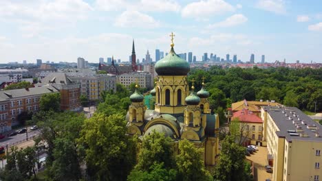 Orthodoxes-Gebäude-Mit-Einer-Historischen-Kirche-Mit-Grünen-Kuppeln-Und-Der-Modernen-Skyline-Der-Stadt-Im-Hintergrund