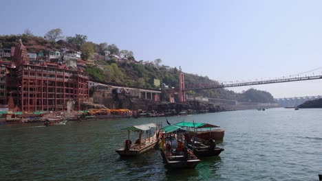 Alter-Hinduistischer-Pilgertempel-Am-Ufer-Des-Heiligen-Flusses-Mit-Touristenfähren-Am-Morgen.-Das-Video-Wurde-Am-10.-März-2024-In-Omkareshwar-Khandwa,-Madhya-Pradesh,-Indien,-Aufgenommen