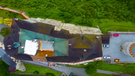 Top-down-view-of-Cesky-Sternberk-Castle,-showcasing-its-roof,-surrounding-walls,-and-lush-green-landscape