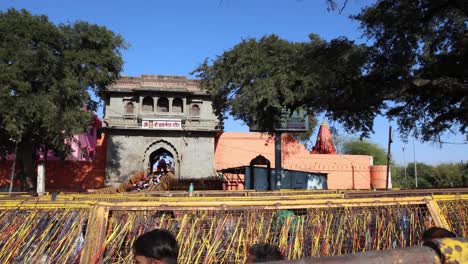 Templo-De-Acebo-Con-Un-Montón-De-Ofrendas-De-Hilos-Sagrados-Hindúes-Y-Personas-Moviéndose-En-Fila-Por-La-Tarde.-El-Video-Fue-Tomado-En-El-Templo-De-Kal-Bhairav-En-Ujjain-Madhya-Pradesh,-India,-El-10-De-Marzo-De-2024.