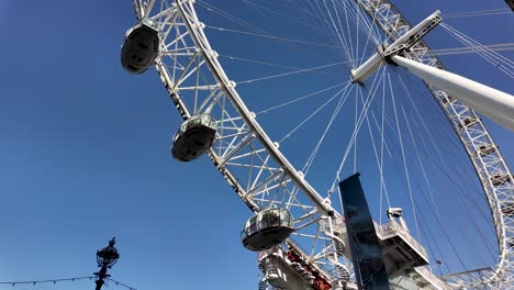 Close-up-of-the-iconic-London-Eye-against-a-clear-blue-sky,-showcasing-its-intricate-design