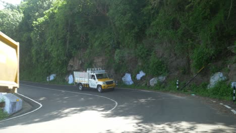 Winding-mountain-road-with-caution-signs-indicating-a-curve,-Hair-pin-bend-road-yellow-sign