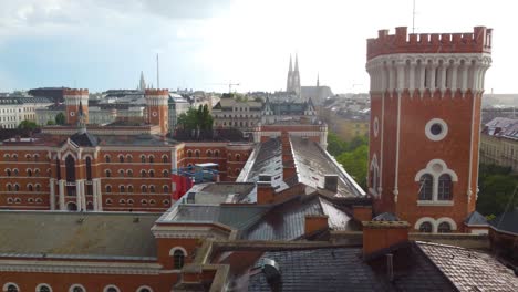 Aerial-view-of-Vienna,-Austria,-during-rain,-featuring-historic-red-brick-buildings-with-a-castle-like-tower