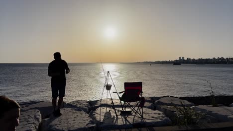 Hombre-Pescando-Al-Atardecer-En-La-Playa