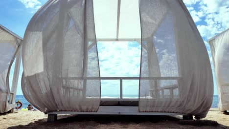 A-white-cabana-with-a-view-of-the-ocean-on-a-sandy-beach-in-Crimea