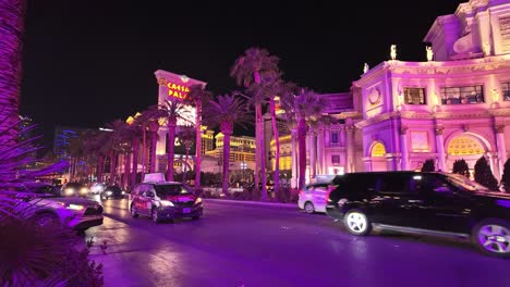 Vibrant-nightlife-scene-of-Caesar's-Palace-with-palm-trees-and-illuminated-facades-on-the-Las-Vegas-Strip