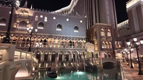 Venezianische-Architektur-Und-Gondel-Auf-Einem-Beleuchteten-Kanal-Bei-Nacht-In-Las-Vegas