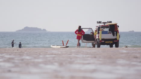 Socorrista-Femenina-Junto-Al-Camión-Patrulla-De-La-Playa-Vigila-A-Los-Nadadores-Por-Seguridad