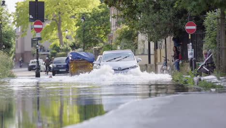 El-Coche-Circula-Por-Una-Carretera-Muy-Inundada-En-El-Reino-Unido-Con-Peatones-En-La-Acera