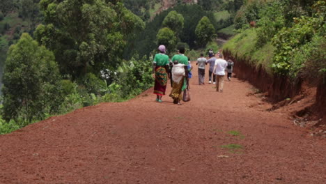 Ländlicher-Weg-Mit-Erwachsenen-Und-Kindern-Zu-Fuß-Zur-Schule-In-Uganda,-Afrika