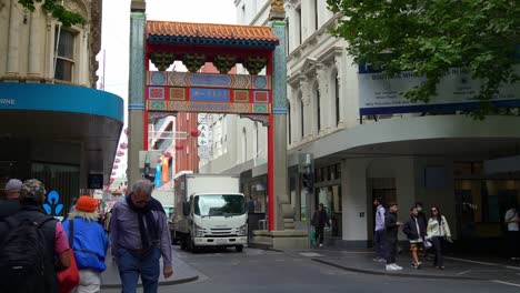 Geschäftige-Innenstadt-Von-Melbourne-Mit-Dem-Wahrzeichen-Chinatown-Mit-Fußgängern,-Die-Den-Zebrastreifen-überqueren,-Und-Autoverkehr-Entlang-Der-Little-Bourke-Street