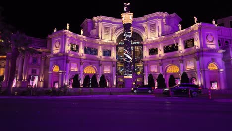 Elegant-night-scene-of-Caesar's-Palace-with-vibrant-purple-lighting-on-the-Las-Vegas-Strip