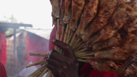 Vendedor-Callejero-Masculino-Negro-Africano-Vendiendo-Brochetas-De-Carne-En-El-Mercado-Local-De-Alimentos