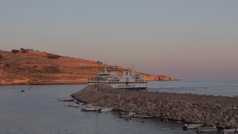 Un-Barco-Ingresa-Al-área-De-La-Bahía-De-Gozo,-Malta,-Capturando-La-Esencia-De-La-Aventura-Náutica-Y-La-Serena-Belleza-De-La-Vida-Costera.