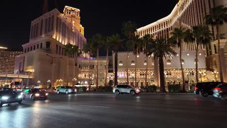 Bustling-night-traffic-and-illuminated-casinos-on-the-Las-Vegas-Strip,-featuring-the-Venetian-and-Wynn