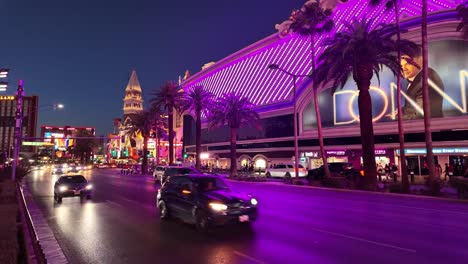 Colorful-evening-scene-with-vibrant-lights,-palm-trees,-and-bustling-traffic-on-the-Las-Vegas-Strip