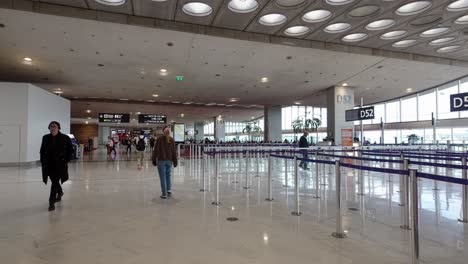 Passing-people-through-the-Charles-de-Gaulle-Airport-Terminal-2's-spacious,-bright-waiting-room-and-hall-in-Paris,-France