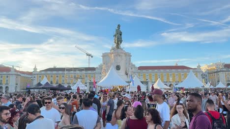 Attendees-happily-dance-and-drink-at-Praça-do-Comércio-Square,-Lisbon,-Portugal,-celebrating-the-Arraial-Lisboa-Pride