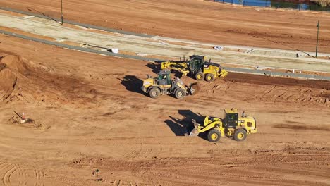 Grader-and-front-end-loader-drivers-meeting-to-discuss-their-work-on-a-new-residential-construction-site