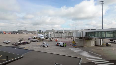 Airplane-preparation-for-takeoff-connected-to-the-passenger-boarding-bridge-at-the-Charles-de-Gaulle-International-Airport-Terminal-2-in-Paris,-France