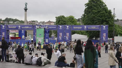 Busy-fanzone-entrance-to-the-public-viewing,-Jubilee-Column-in-Stuttgart,-Germany-during-Euro-2024,-people-passing-by,-static-near