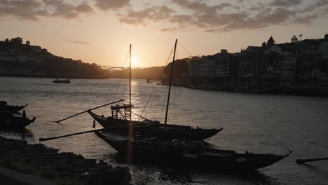 Silueta-De-Barcos-Rabelo-En-El-Río-Duero-Al-Atardecer,-Porto,-Portugal