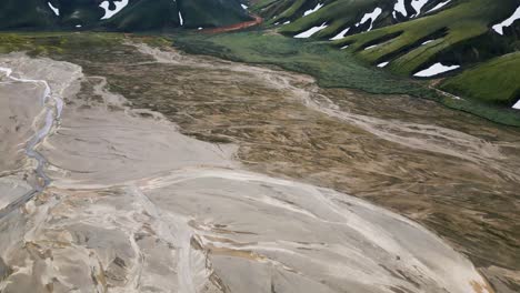 Icelandic-highlands-showcasing-vast,-rugged-terrain-and-green-mountains,-aerial-view