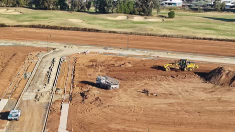 Descripción-Aérea-De-Una-Niveladora-Nivelando-Tierra-En-Un-Nuevo-Sitio-De-Construcción