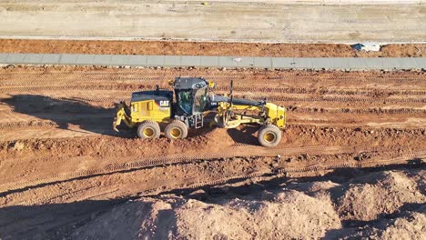 Niveladora-Trabajando-Duro-Para-Nivelar-Grandes-Montones-De-Tierra-En-Un-Nuevo-Sitio-De-Construcción-Residencial