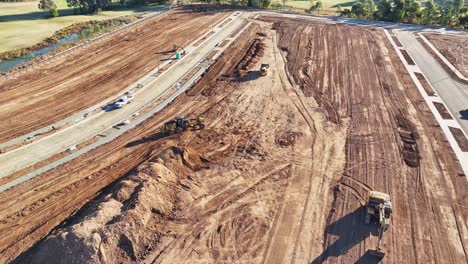 Descripción-Aérea-De-Un-Sitio-De-Construcción-Con-Una-Niveladora-Y-Un-Cargador-Frontal-Trabajando