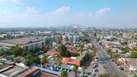 Autumnal-establishing-shot-of-Santiago-de-Chile-South-American-town-daylight-sky-shines,-aerial-drone-fly-above-streets-and-buildings,-Andean-cordillera-background