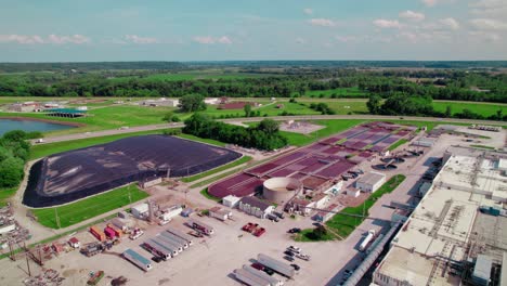 Luftaufnahme-Eines-Viehverteilzentrums-Mit-Geparkten-Kühlanhängern-Und-Einer-Angrenzenden-Abwasseraufbereitungsanlage