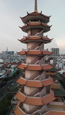 Buddhist-temple-or-pagoda-prayer-tower-in-late-afternoon-light-with-city-skyline-and-urban-sprawl-of-Ho-Chi-Minh-City,-Vietnam