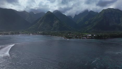 Teahupoo-wave-Tahiti-French-Polynesia-aerial-drone-sunny-cloudy-morning-mountain-valley-peaks-Paris-summer-Olympics-venue-Passe-Havae-channel-coral-reef-Point-Faremahora-surf-surfer-break-forward-up