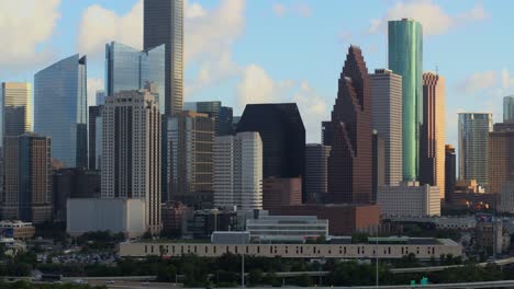 Aerial-shot-of-downtown-Houston-moving-to-the-right-revealing-cars-on-I-45-freeway