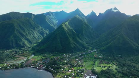 Teahupoo-Tahití-Polinesia-Francesa-Aéreo-Zumbido-Durante-El-Día-Soleado-Verde-Isla-Picos-De-Las-Montañas-Pueblo-Pueblo-París-Sede-De-Los-Juegos-Olímpicos-De-Verano-Monte-Orohena-Aorai-Ronui-Cielo-Azul-Río-Valle-Círculo-Izquierda