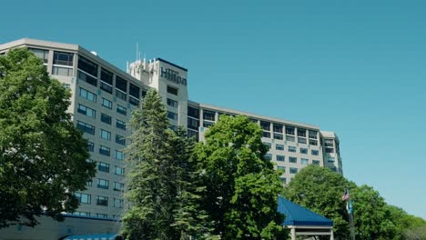 Exterior-view-of-Hilton-Chicago---Oak-Brook-Hills-Resort-and-Conference-Center,-surrounded-by-lush-green-trees-on-a-clear-day